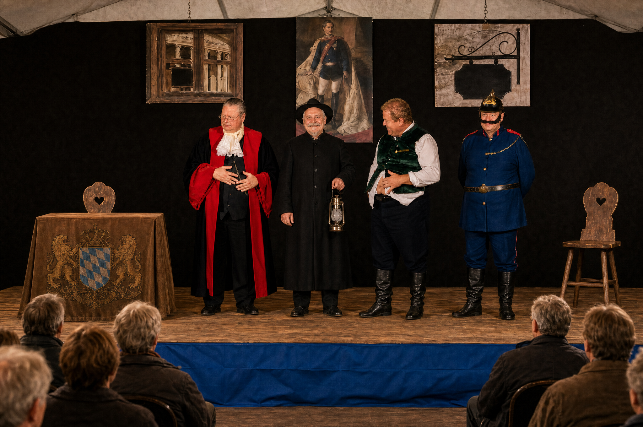Blick vom Zuschauerraum auf die Bühne im Kulturzelt: vier Darsteller in Kostümen des 19. Jahrhunderts vor einer schwarzen Bühnenwand mit dem Bildnis König Ludwigs II., links ein kleiner Tisch mit braunem Tuch und königlich bayerischem Wappen